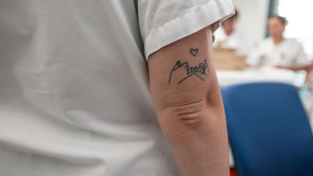 Bras d’un patient avec tatouage en salle de soins hospitalière